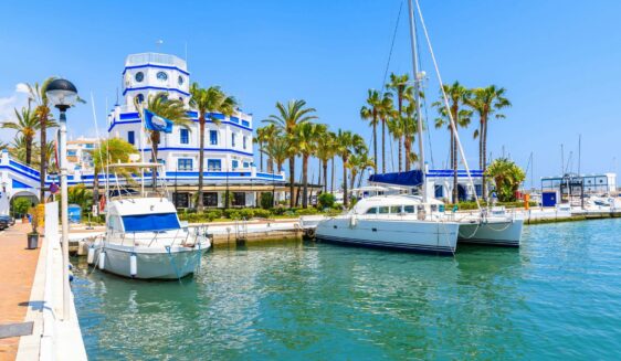 Boats and beautiful lighthouse building in Estepona port on Costa del Sol coast, Spain